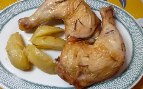 Cosce di pollo in friggitrice ad aria, dorate e succulente, servite con patate arrosto.
