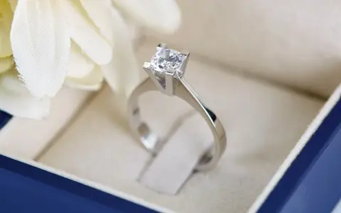 Anello con diamante in un cofanetto blu. La brillantezza del diamante, misurata in carati, cattura la luce.
