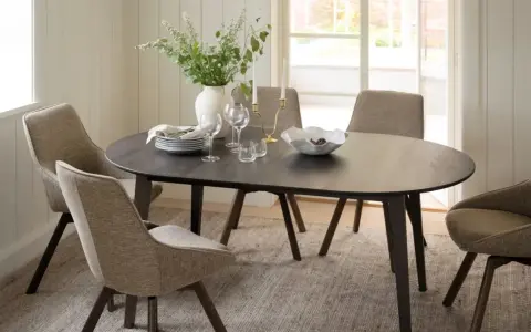 Ett elegant matbord med stolar i en ljus miljö, typiskt för ett Rowico showroom.