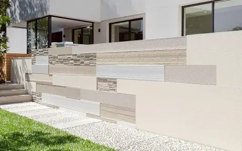 Un muret extérieur aux textures variées, allant du grain fin au bois, est prêt à enduire pour un look moderne et élégant.