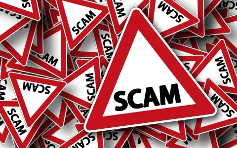 Viele rote Dreiecke mit der Aufschrift "SCAM" stapeln sich. Vorsicht vor der aktuellen Online-Betrugsmasche!