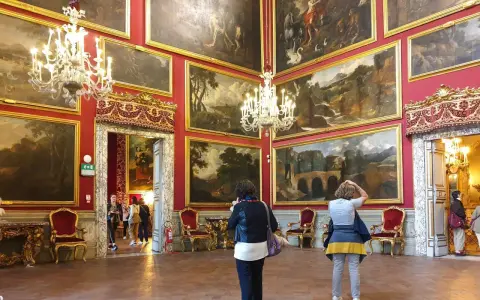 Wnętrze Galerii Doria Pamphilj z obrazami i żyrandolami.