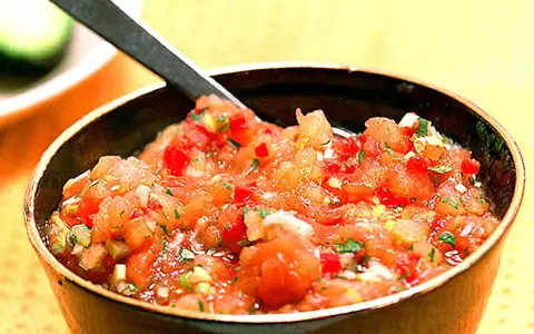 En skål med färsk pico de gallo, en klassisk mexikansk salsa med hackade tomater, lök och koriander. Perfekt till tacos!
