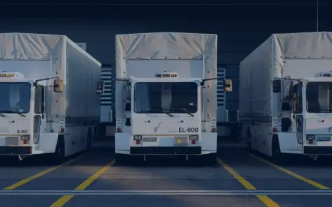 Drei weiße LKWs stehen nebeneinander vor einem Gebäude. Ein LKW-Fahrverbot am Wochenende könnte hier gelten.