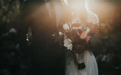Para młoda w blasku słońca, trzymająca bukiet. Czy urlop okolicznościowy kiedy przepada, gdy ślub jest tak piękny?