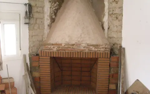 Construcción de chimenea de obra. El hogar de ladrillo y la campana cónica de cemento están en proceso. Aprende como hacer una chimenea de obra que no haga humo.