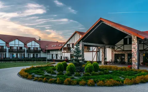 Elegancki hotel Mikołajki Spa z charakterystyczną architekturą i zadbanym ogrodem zaprasza na wypoczynek.