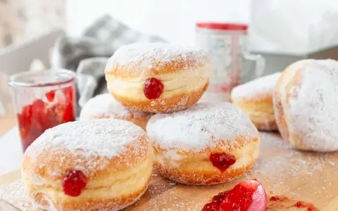Frisch gebackene Krapfen im Airfryer, mit Puderzucker bestäubt und leckerer Marmelade gefüllt.
