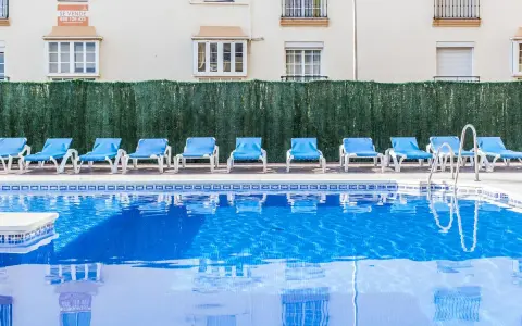 Błękitne morze przy hotelu Gran Cervantes, puste leżaki czekają na gości.