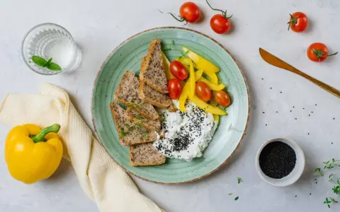 Talerz z twarogiem, pieczywem, pomidorkami i papryką. Idealne na śniadanie z serii dieta wysokobiałkowa przepisy.