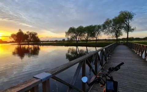 Zachód słońca nad jeziorem, drewniana promenada augustów zaprasza na spacer.
