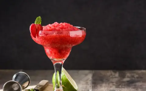 En fryst strawberry daiquiri med mynta och jordgubbsdekoration, redo att avnjutas.