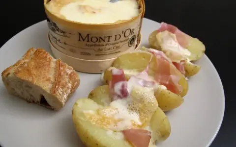 Un Mont d'Or fondant, pommes de terre et jambon cru : un plat réconfortant, typique des spécialités du Jura.