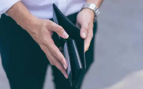 Puste ręce trzymające portfel, symbolizujące trudności finansowe i przykłady stagflacji.