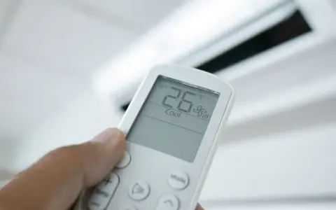 Mando a distancia de aire acondicionado mostrando 26°C en modo "Cool". El modo "Dry" deshumidifica el aire.