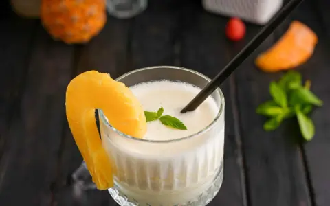 En krämig pina colada med ananasskiva och mynta. Perfekt för en solig dag.