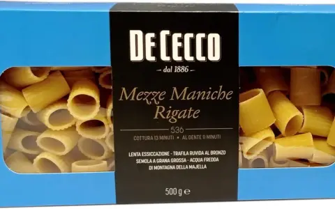 Pudełko makaronu De Cecco Meze Maniche Rigate, z widocznym przez okienko makaronem. Wybór między Makaron Barilla czy De Cecco?