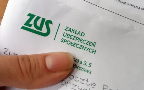 Palec wskazujący na dokumencie ZUS. Pytanie: ile trzeba być na zwolnieniu aby dostać odszkodowanie z ZUS?