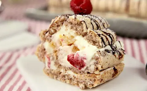 En läcker budapestbakelse med grädde och frukt, toppad med en hallon och chokladdrizzle.