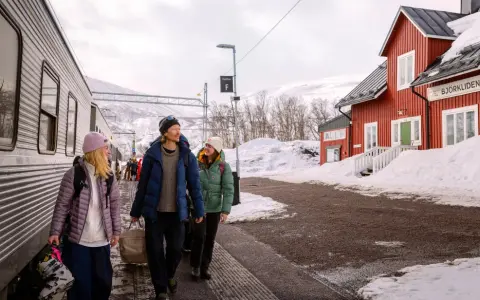 Tre vänner anländer till Björkliden med tåg, redo för vinteräventyr. En röd stationsbyggnad och snöklädda berg vittnar om att de är framme vid en av Sveriges mest natursköna platser, inte långt från evens flygplats.