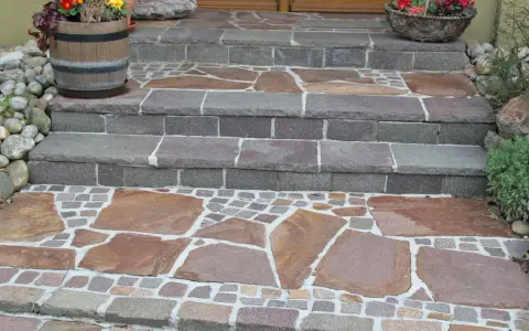 Stufen mit polygonalplatten verlegen. Große, unregelmäßige Steinplatten und kleine Pflastersteine bilden ein schönes Muster.