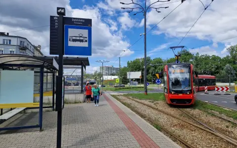 Przystanek Dęblińska w Sosnowcu. Tramwaj czeka na pasażerów, a rozkład jazdy MZK jest widoczny na słupie.