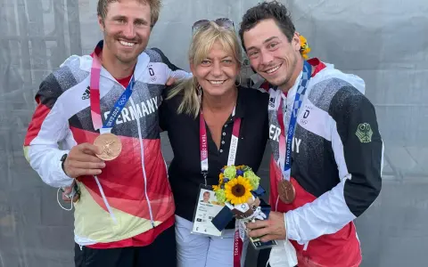 Tatjana Pokorny mit zwei Medaillengewinnern des Team Deutschland bei den Olympischen Spielen in Tokio.