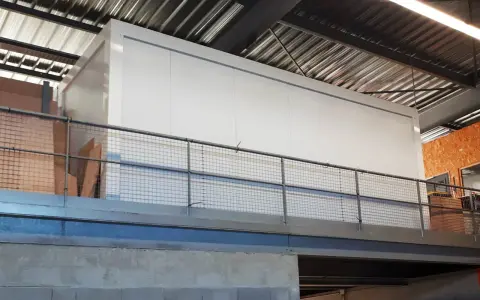 Un grand module blanc, peut-être une chambre froide, est installé dans un entrepôt. Le **REI 120 signification** est la résistance au feu de 120 minutes, une norme de sécurité essentielle.