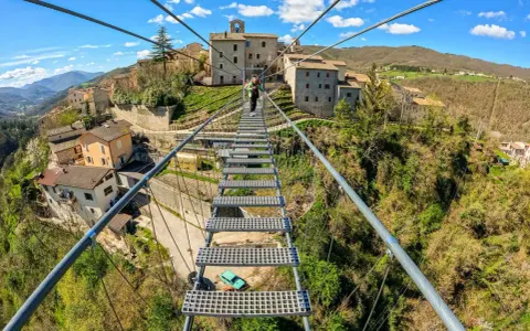 Ponte tibetano sellano, una passerella sospesa che collega borghi antichi, offre una vista mozzafiato sulla valle. La sua lunghezza è un'avventura.
