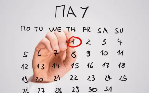 Ręka zakreśla czerwonym pisakiem datę 1 maja na kalendarzu. To ważne awizo, początek miesiąca.