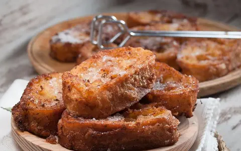 Torrijas caseras, doradas y espolvoreadas con azúcar. Una deliciosa receta para disfrutar.