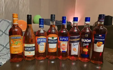 Rząd pomarańczowych butelek aperitifów, w tym Campari i Aperol, gotowych na wieczór.