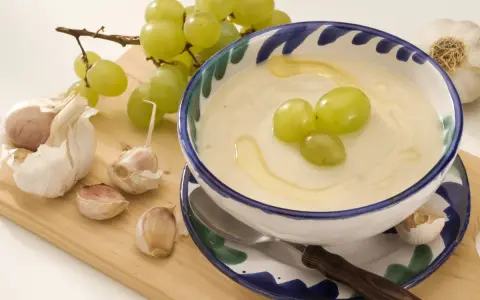 Ajoblanco en cuenco con uvas verdes, ajos y aceite de oliva.