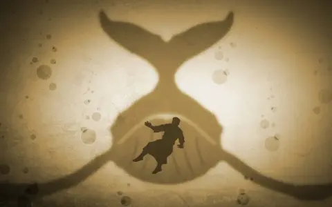 A silhouette of a man falls into the mouth of a giant whale, a classic sign of Jonah's story.