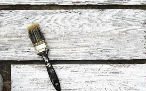 Pennello sporco su assi di legno bianco, pronto per la cementite per legno già verniciato.