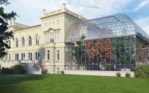 Elegancka willa z oranżerią, prawdopodobnie najdroższy hotel w Łodzi, otoczona zielonym trawnikiem.