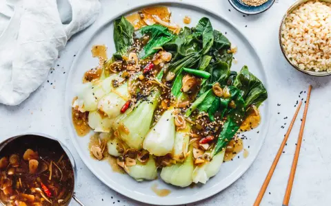 Ein köstliches Hauptgericht mit Pak Choi, serviert mit einer würzigen Sauce und Sesam. Perfekt für ein gesundes Abendessen.