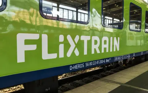 Zielona lokomotywa FlixTrain Polska na torach, gotowa do podróży.