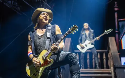 Ein Gitarrist mit Hut spielt auf der Bühne, im Hintergrund ein weiterer Musiker. Ein Konzert von Alice Cooper.