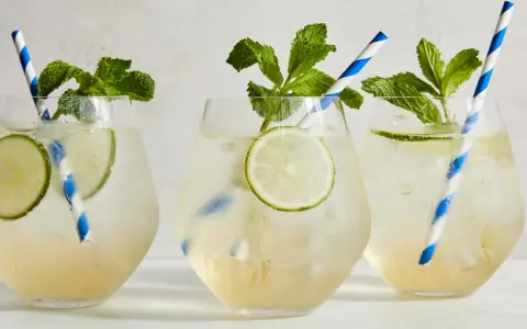 Tre svalkande Hugo Spritz med mynta och lime, perfekta för en solig dag.