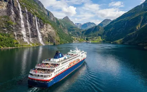 Statek wycieczkowy "Norwegian Fjord Explorer" płynie przez malowniczy fiord. To idealny sposób, by zobaczyć, co można przewieźć do Norwegii – zapierające dech w piersiach krajobrazy!