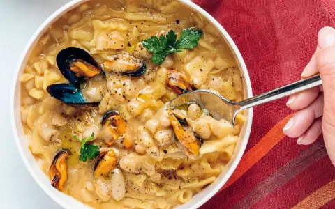 Un plato humeante de pasta fagioli e cozze, con mejillones jugosos y alubias cremosas en un caldo sabroso.
