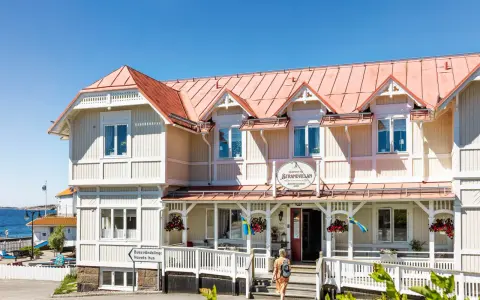 Välkommen till Strandvillan i Lysekil, ett charmigt hus vid havet med röda tak och vita detaljer.