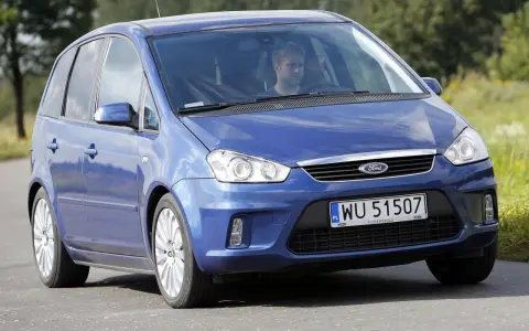 Niebieski Ford C-Max 1.6 TDCI z mężczyzną za kierownicą jedzie po drodze wśród zieleni.