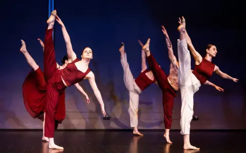 Tancerze wykonują dynamiczny jazz dance, unosząc nogi w powietrze.