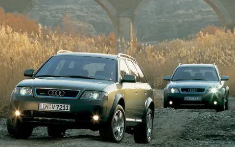 Dwa Audi A6 C5 2.5 TDI Allroad jadące po kamienistej drodze, w tle łuk mostu i suche trawy.