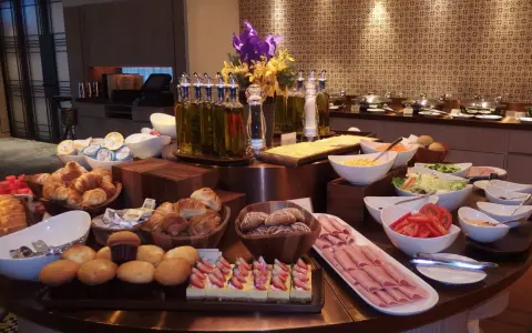 Ideas para buffet desayuno hotel: croissants, pasteles de fresa, jamón, ensaladas, frutas y panes.