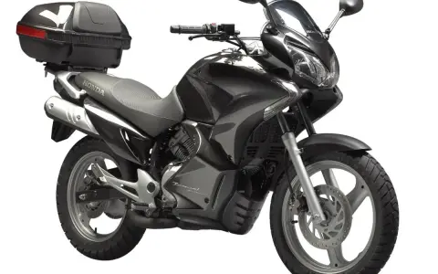 Czarny motocykl Honda Varadero 125 z kufrem, gotowy na podróż.