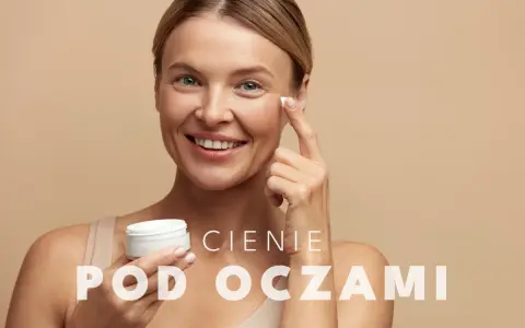Uśmiechnięta kobieta aplikuje krem pod oczy. To rozwiązanie na cienie pod oczami, które przywróci blask Twojej skórze.