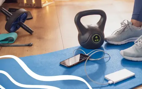 Gotowy na trening cardio? Kettlebell, gumy oporowe, rolka do ćwiczeń i telefon z powerbankiem czekają na matę.